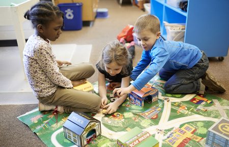 Children playing on map rug